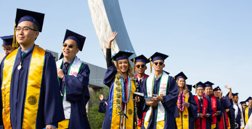 students graduating and walking by the beginnings sculpture on uc merced campus